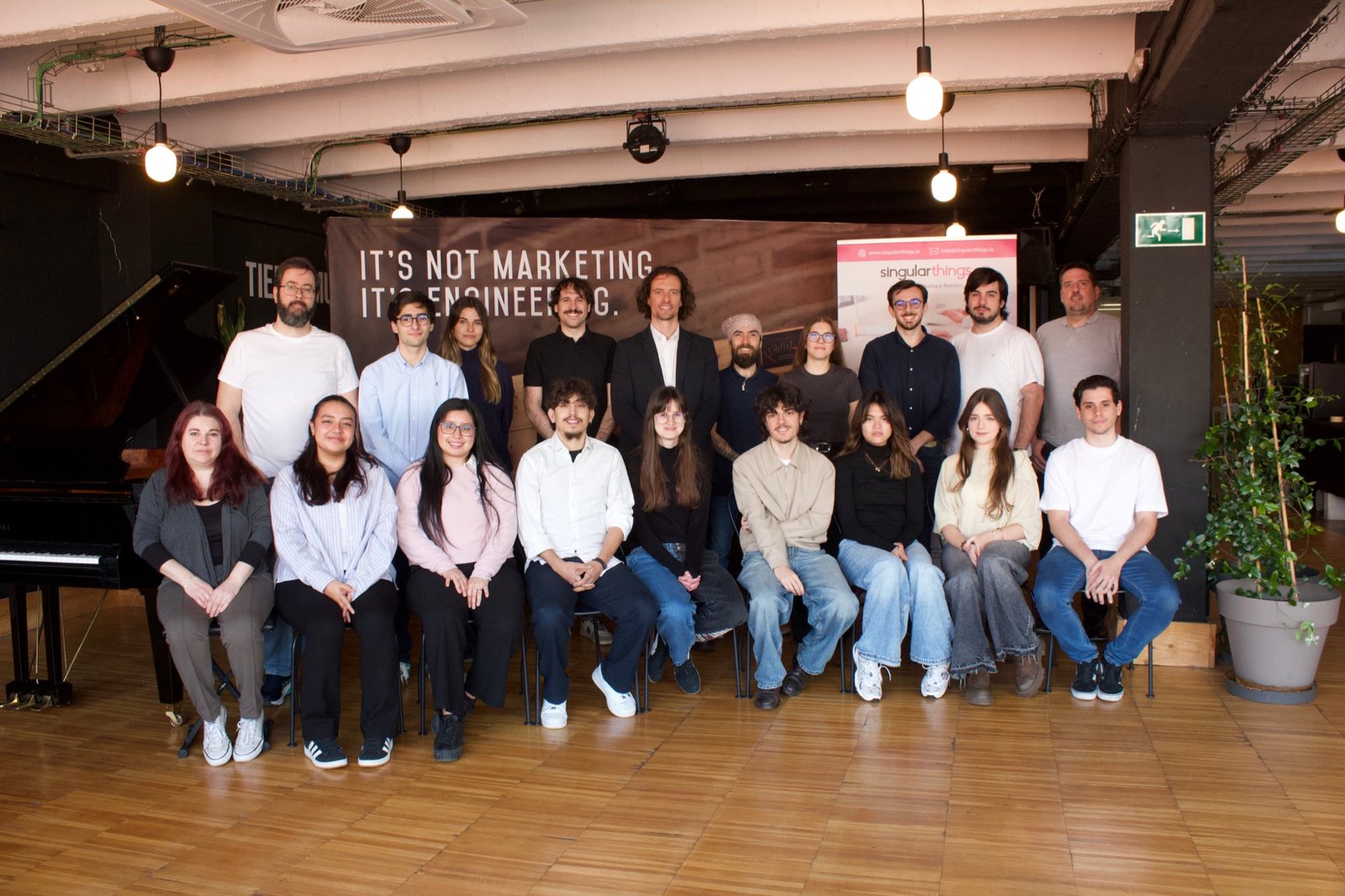 El equipo de Singular Things en su taller de Madrid, bajo el neón “It's not marketing. It's engineering.”
